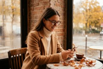 Jeune femme portant des lunettes oversize en acétate écaille de tortue dans un café parisien en automne