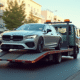 Voiture moderne chargée sur une dépanneuse en ville en journée